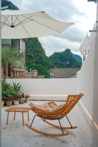 a chair and a table and an umbrella on a balcony at Leye Inn in Yangshuo