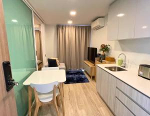 a kitchen and living room with a white table and chairs at Pool View Marvest Huahin by Wilmot in Hua Hin