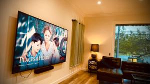 a large flat screen tv on a wall in a living room at The Dream Cottage in Los Angeles