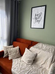 een oranje bank met kussens in een slaapkamer bij Loft 406 in Curitiba