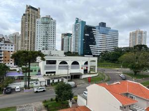 een uitzicht op een stad met een parkeerplaats en gebouwen bij Loft 406 in Curitiba