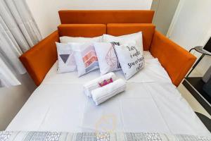 een oranje bed met witte kussens erop bij Loft 406 in Curitiba