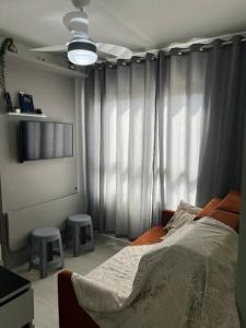 een slaapkamer met een bed en 2 krukken bij Loft 406 in Curitiba