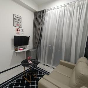 a living room with a couch and a television at URBAN SUITES JSW STUDIO 3 ROOMS COMMERCIAL CONDO in Jelutong