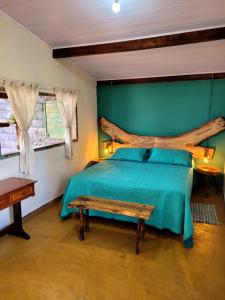 una camera con letto in legno e panca di legno di Pousada Fazenda São Pedro a Delfinópolis