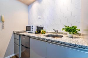 a kitchen counter with a sink and a microwave at jerusalemvip in El Muṣrāra