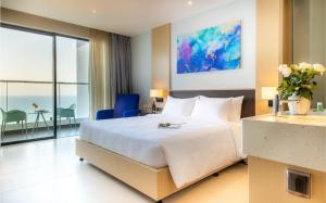 um quarto de hotel com uma cama grande e vista para o oceano em Arena Apart-Resort Cam Ranh with Ocean view-Private beach em Cam Ranh