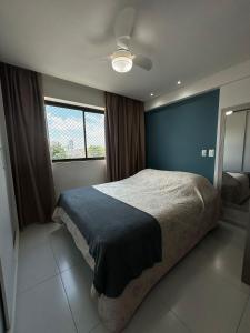 a bedroom with a large bed with a blue wall at Studio Beira Mar - Sem Taxas in Recife