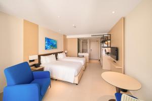 um quarto de hotel com uma cama e uma cadeira azul em Arena Apart-Resort Cam Ranh with Ocean view-Private beach em Cam Ranh