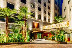 een hotel met palmbomen voor een gebouw bij Hotel Lotus Okayama Adult Only -Adult Only in Okayama