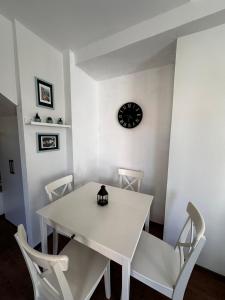a white table and chairs with a clock on the wall at Villa Carian Trail Datca , Kargi Koyu , plaja yakin in Datca