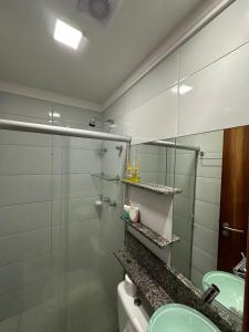 y baño con ducha acristalada y lavamanos. en Excelente localização na zona norte - Sem Taxas, en Recife