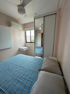 a bedroom with a large bed and a mirror at Excelente localização na zona norte - Sem Taxas in Recife