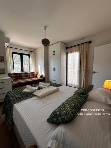 una camera da letto con un grande letto con cuscini sopra di Villa Carian Trail Datca , Kargi bay , close to beach a Datça