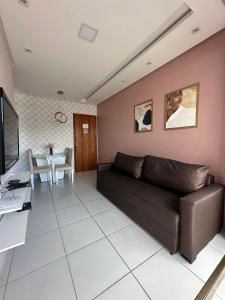 uma sala de estar com um sofá e uma mesa em Excelente localização na zona norte - Sem Taxas no Recife