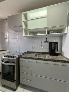 a kitchen with a sink and a stove at Excelente localização na zona norte - Sem Taxas in Recife