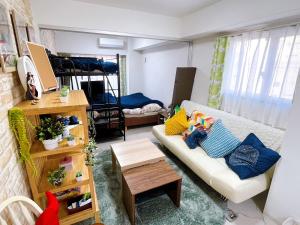 a living room with a couch and a bed at LANDMARK NAMBA EBISUCHO chan in Osaka