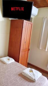 une chambre avec un panneau Netflix au-dessus d'un lit dans l'établissement Hostería El Alemán, à Cosquín 6 autres photos