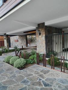 un edificio con un patio con plantas y una pared de piedra en Departamento con exelente ubicacion en Pucón