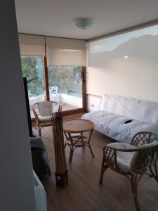 1 dormitorio con 1 cama, mesa y sillas en Departamento con exelente ubicacion, en Pucón