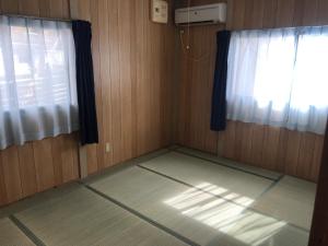 Marine Lodge Umigoya - Vacation STAY 23057v في زمامي: غرفة بها نافذتين وأرضية بها