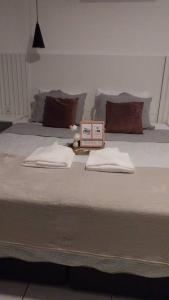 uma cama com duas almofadas com duas toalhas em Studio confortável, na Marambaia. em Belém