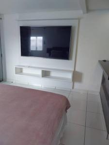 uma sala de estar com uma televisão na parede em Studio confortável, na Marambaia. em Belém