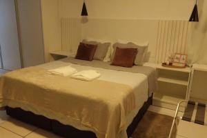 um quarto com uma cama grande e 2 almofadas em Studio confortável, na Marambaia. em Belém