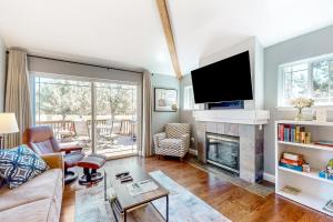 a living room with a fireplace and a flat screen tv at Eagle Crest home located on the Challenge Course in Redmond