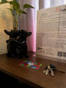 eine Statue eines schwarzen Hundes auf einem Tisch mit Schlüsseln in der Unterkunft Habitación Cuitláhuac en Apartamento Compartido in Mexiko-Stadt