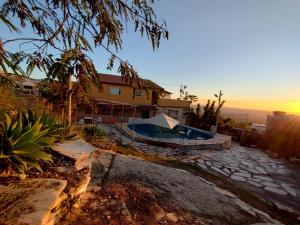 a house with a swimming pool in a yard at Recanto das Pedras Hospedagem in São Thomé das Letras