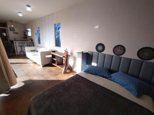 a bedroom with a bed and a living room at Recanto das Pedras - Loft Container in São Thomé das Letras
