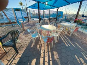 a patio with tables and chairs with a view of the ocean at Duerme en un hermoso Velero dentro de la Marina in La Paz