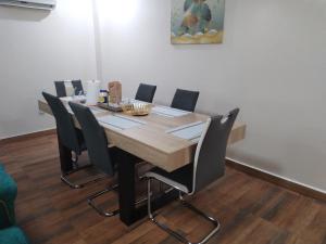 sala konferencyjna z drewnianym stołem i krzesłami w obiekcie Appartement Elegant w mieście Konakry