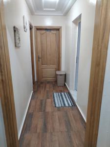 korytarz z drewnianymi drzwiami i podłogą w obiekcie Appartement Elegant w mieście Konakry