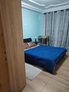a bedroom with a bed with a blue comforter at Appartement Elegant in Conakry