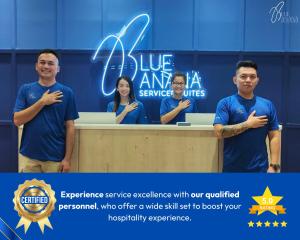 a group of people standing behind a desk at The Apple Suites Melaka by BlueBanana in Malacca