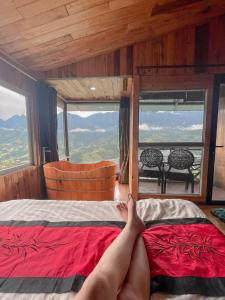 a person laying on a bed in a room with a window at VALLEY VIEW COFFEE & STAY in Sa Pa