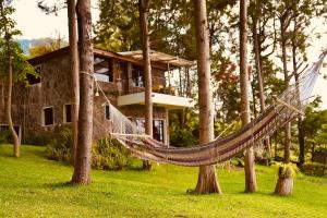 a hammock in front of a tree house at Inlaquesh Villa Atitlán in Cerro de Oro