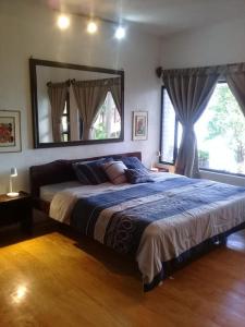1 dormitorio con 1 cama grande y espejo grande en Inlaquesh Villa Atitlán, en Cerro de Oro