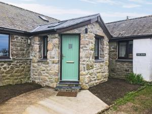 ein Steinhaus mit grüner Tür in der Unterkunft Tor Barn in Lower Boscaswell