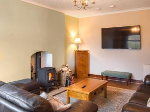 a living room with a couch and a wood stove at Fraser Terrace in Leadhills