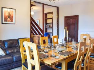 a dining room with a table and a couch at Fraser Terrace in Leadhills