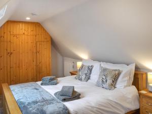 um quarto com uma grande cama branca com almofadas em Fraser Terrace em Leadhills