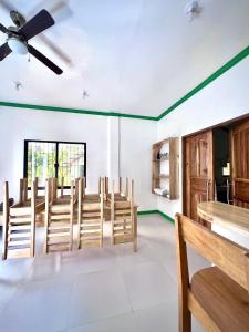 a dining room with wooden chairs and a ceiling fan at NOGS Homestay, near Magpupungko, Siargao Island Surfings Spots in Pilar