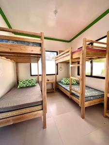 a room with three bunk beds in a house at NOGS Homestay, near Magpupungko, Siargao Island Surfings Spots in Pilar