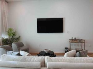 uma sala de estar com 2 sofás brancos e uma televisão de ecrã plano em Luxury Condo in Prime Location (Pet-Friendly) em New Braunfels