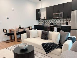 a living room with a white couch and a kitchen at Luxury Condo in Prime Location (Pet-Friendly) in New Braunfels