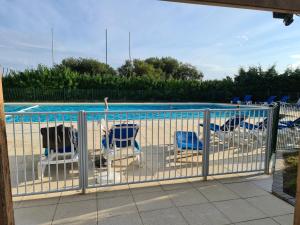a fence with chairs and a swimming pool at Appartement Arzon, 2 pièces, 5 personnes - FR-1-639-17 in Arzon
