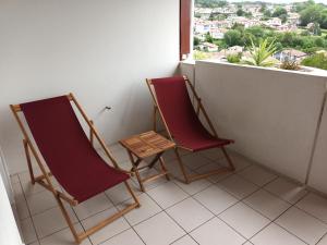 two chairs sitting on a balcony looking out a window at Appartement Hendaye, 2 pièces, 4 personnes - FR-1-239-777 in Hendaye